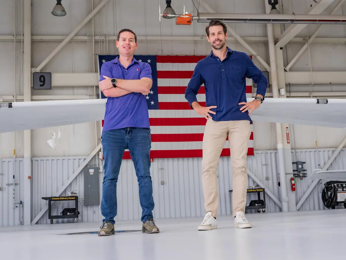 The founders standing in front of a new aircraft and an American flag